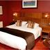 Beamish Park Hotel bedroom in Newcastle upon Tyne with double bed, wood headboard and red walls