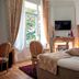 Hôtel La Casa Pairal in Collioure guest room with four-poster bed, fireplace, and tall window