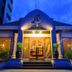 Mida Hotel Don Mueang Airport in Bangkok, lit exterior entrance with steps and glass doors at dusk
