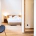 Landhotel Kauzenberg in Bad Kreuznach: modern room with lounge chair and bed