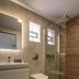 Kaliviani Traditional Hotel in Kissamos: modern bathroom with wall-mounted sink, toilet, glass shower and wood-look floor