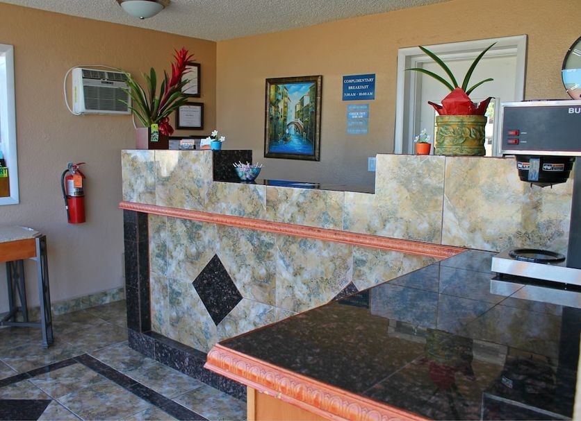 Stone Inn Extended Stay U of A lobby front desk in Tucson with granite counters and potted plants