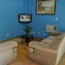 Hotel Blue Star II lounge with blue walls, two beige sofas, wall-mounted TV and small table in Foz do Iguaçu