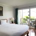 Chada Thai House Pattaya guest room with bed, balcony, and sliding glass door