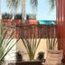 Hotel Del Pescador in Ajijic with patio chairs, tropical plants, palm trees, and a turquoise pool
