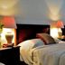 La Ermita de Santa Lucia Antigua twin-bed guest room with bedside lamps and dark wood furniture