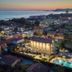 Hotel Villa Tiziana in Marina di Massa with illuminated pool and sea view at dusk