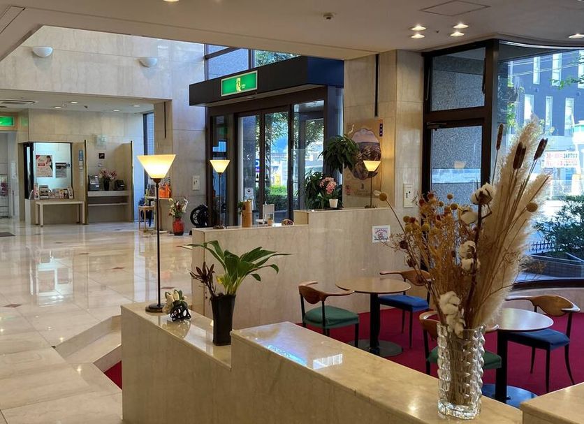 Sky Hotel Matsuyama lobby with polished floors, seating area, glass entrance, and city-view windows