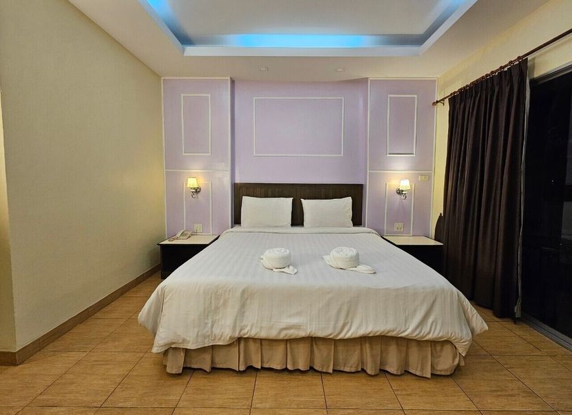 Baan Suksiri Hotel Hua Hin bedroom with king bed, bedside lamps and sliding glass door