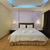Baan Suksiri Hotel Hua Hin bedroom with king bed, bedside lamps and sliding glass door