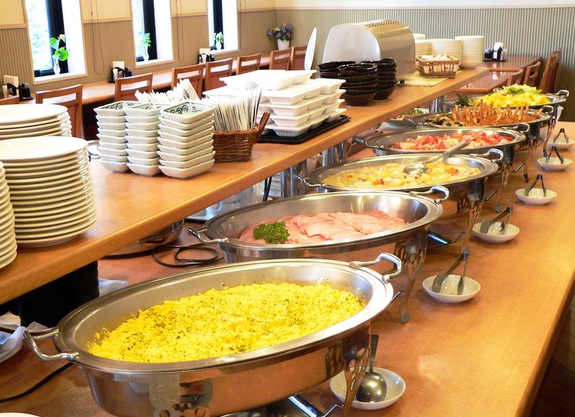 Hotel Route-Inn Court Kashiwazaki breakfast buffet with hot dishes, plates, and serving trays