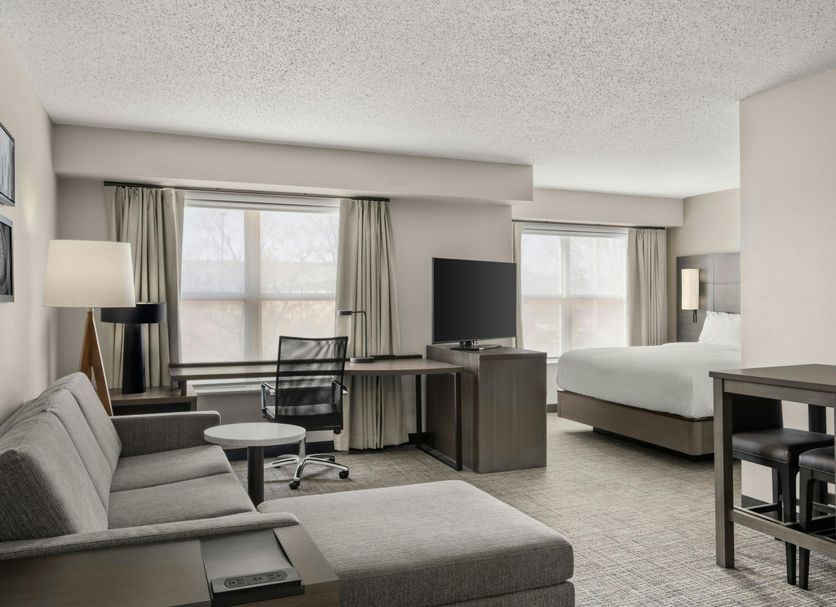 Residence Inn by Marriott Davenport suite with sofa, desk, bed, and dining table in a bright room