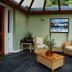 Bryn Melyn Apartments in Barmouth conservatory lounge with wicker seating and glass roof