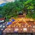 Onda D'oro Hostel Yeosu terrace with string lights, trees, seating, and hillside views