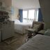 Windjammer BY The Sea Hampton guest room with bed, sitting chair and balcony view