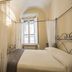 B&B Quattro Cantoni in Siena bedroom with canopy bed, sheer curtains, and arched ceiling