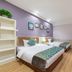 East Garden Hotel Chongqing guest room with two beds, lavender walls, wood floors, and white shelving