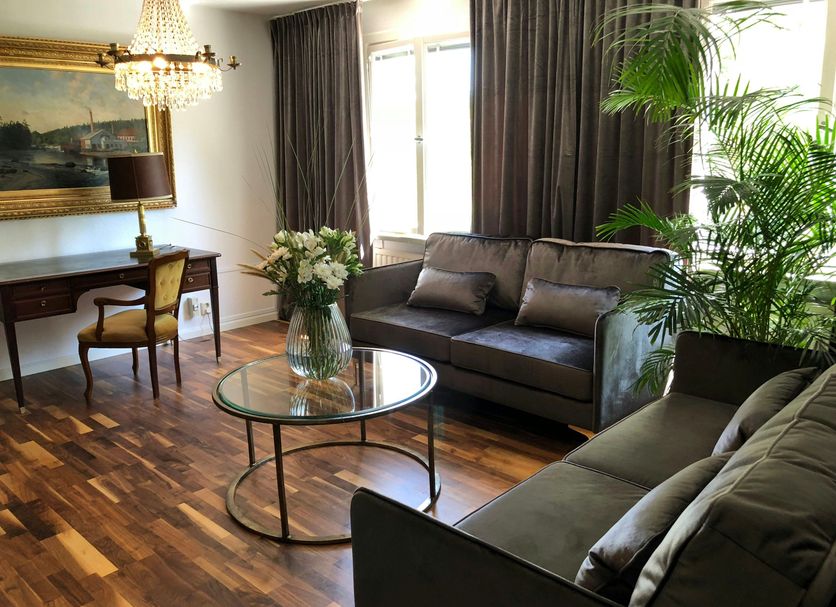 Åsby Hotell in Hallstahammar lounge with leather sofas, glass coffee table, desk and chandelier