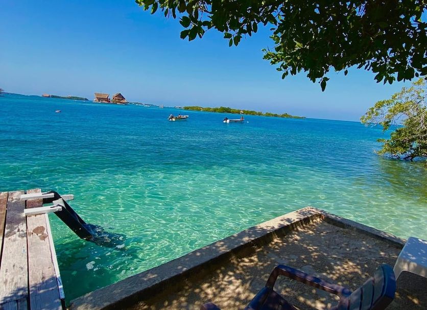 Isla Los Erizos Ecohouse in Islas del Rosario with clear turquoise sea and wooden dock