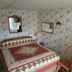 Windjammer BY The Sea room with floral wallpaper, quilted bed, chair, and mini fridge in Hampton