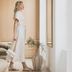 1.75 Paris La Source in Paris: woman standing in a bright minimalist hotel room with cushions and a vase