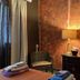 Coqui del Mar Guesthouse in San Juan room with ornate mirror, lamp, chair, dresser and folded towels