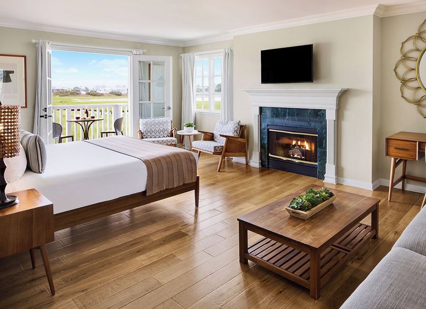 Inn at Playa del Rey, Los Angeles guest room with fireplace, king bed and balcony view of greenery