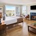 Inn at Playa del Rey, Los Angeles guest room with fireplace, king bed and balcony view of greenery