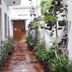 La Villa Creole Pondicherry courtyard corridor with potted plants and wooden doors