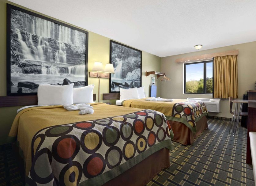 Super 8 by Wyndham Russellville guest room with two beds, window view, and TV in Russellville
