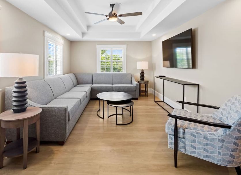 Love Farms Lodge in West Dennis living room with gray sectional, wall TV, coffee table and armchair