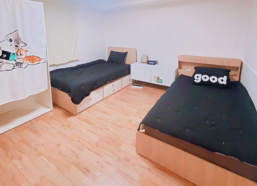 Naru Hostel Seoul twin room with two single beds and light wood flooring