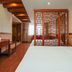 Education Hotel Guilin guest room with bed, desk, TV, and decorative wooden room divider