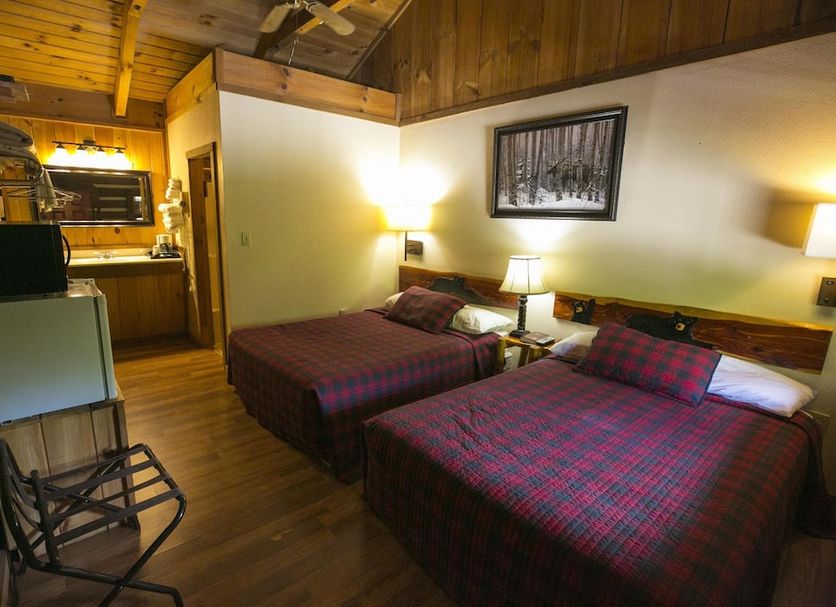 Black Bear Lodge Motel in Slade: rustic double room with two beds, wood ceiling and warm lamps