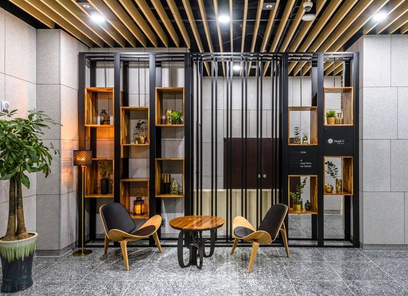 Hotel With Jeju in Jeju City lobby seating area with wood slat ceiling and display shelves