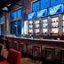 Aloft Seattle Redmond bar and lounge with high-top seating, lit tables, and large windows in Redmond