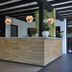 Hotel Bieze in Borger reception desk with wood finish, hanging pendant lights, and potted plants