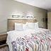 Red Roof Inn Dayton North Airport room with king bed, patterned duvet, and open bathroom door in Dayton