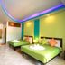 Seashell Resort Krabi room with two green beds and colorful ceiling lights in Krabi