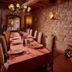 Pêche De Vigne & Spa in Rodern dining room with long set table, stone walls, chandelier and wood stove