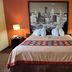 Super 8 by Wyndham Altoona guest room with king bed, cityscape wall art and bedside lamps