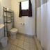 Star Inn Karnes City bathroom with toilet, pedestal sink, shower curtain and towel shelf