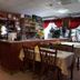 Hotel Hajnal in Mezőkövesd bar and dining area with tables, counter, and red curtains