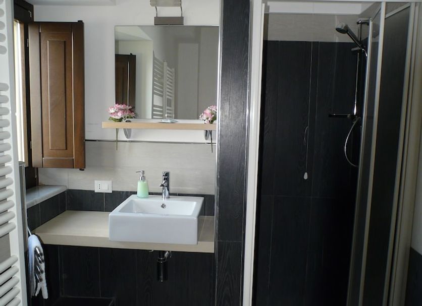 Sicily Rooms Enna bathroom with sink vanity, mirror, and glass shower enclosure in Enna