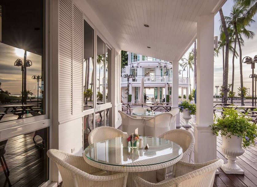 Ambassador City Jomtien Pattaya - Ocean Wing patio with glass table, chairs, palms and oceanfront view in Pattaya