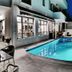 Erato Hotel in Agia Marina with a lit outdoor pool beside a modern building and lounge chairs