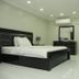 White Fort Hotel Dubai guest room with bed, dresser, wall mirror, TV and chair