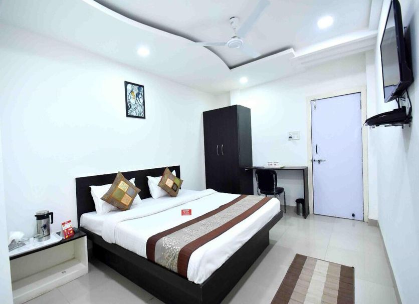 OYO 3815 Hotel Jaisingh Palace room in Indore with double bed, wall-mounted TV, wardrobe and desk