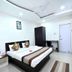 OYO 3815 Hotel Jaisingh Palace room in Indore with double bed, wall-mounted TV, wardrobe and desk