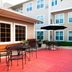 Residence Inn by Marriott Oklahoma City South courtyard patio with tables, chairs and black umbrellas